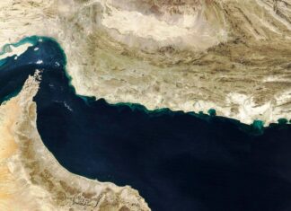 Irã cobra US$ 2 mi para navios passarem por Ormuz – 27/03/2026 – Mundo Imagem de satélite mostra o Estreito de Ormuz entre a Península Arábica ao sul e o Irã ao norte. Águas escuras do estreito contrastam com áreas desérticas claras nas margens.